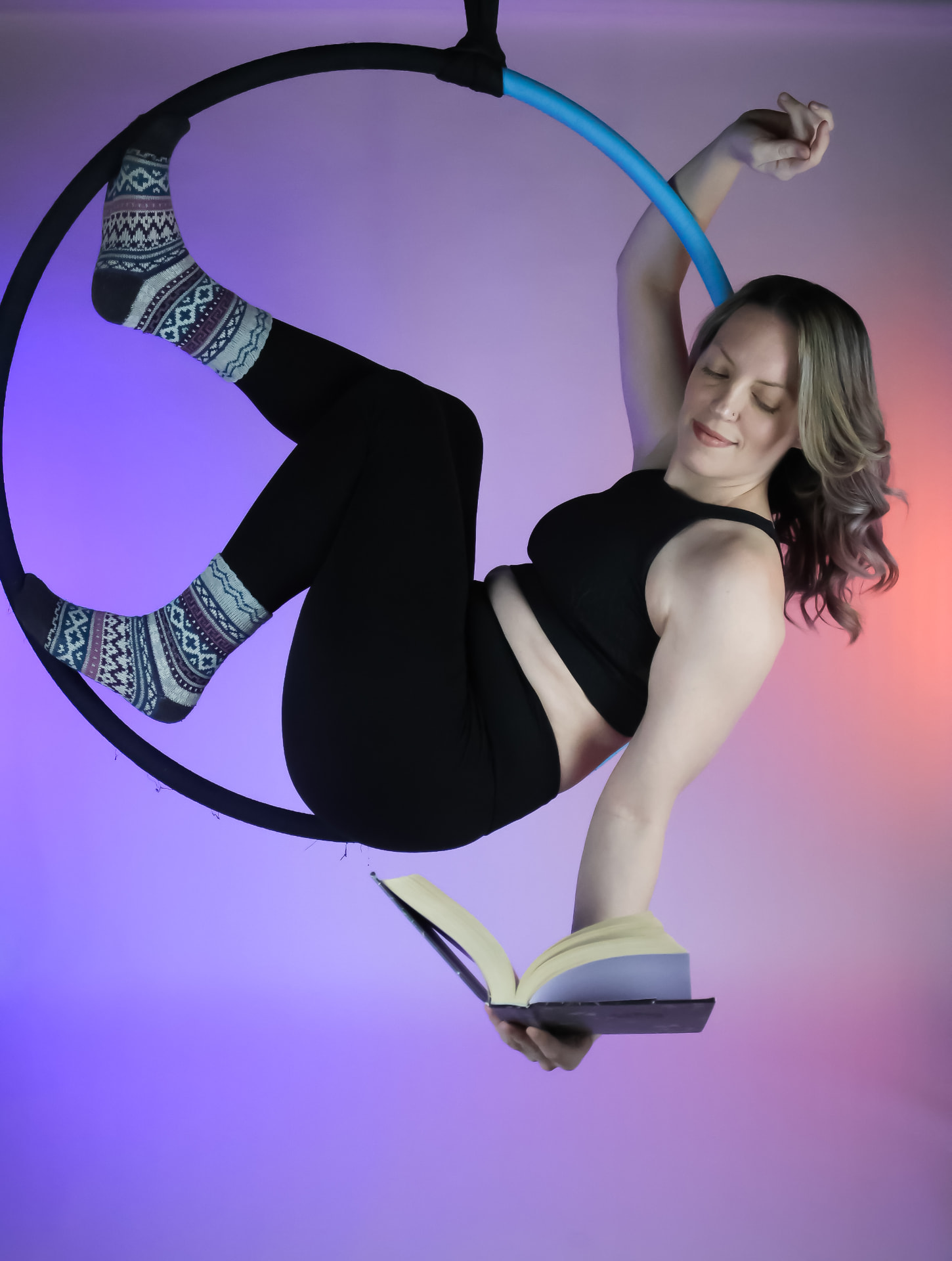 Aerialist relaxing in a lyra hoop at the studio